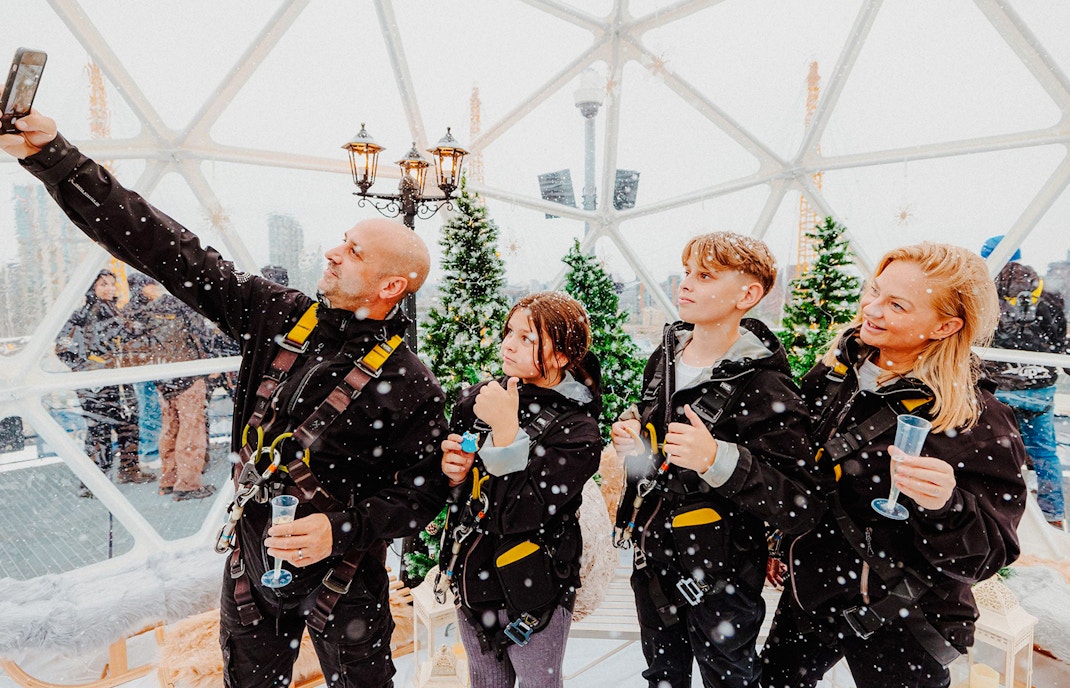 Guests enjoying the Up at the O2 Snow Globe Experience in winter gear.