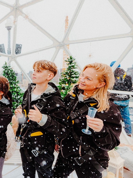 Guests enjoying the Up at the O2 Snow Globe Experience in winter gear.