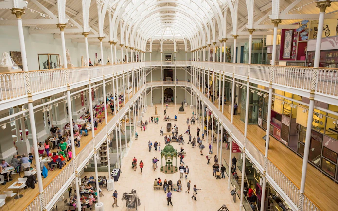 Visitors exploring the grand atrium of the National Museum of Scotland in Edinburgh.