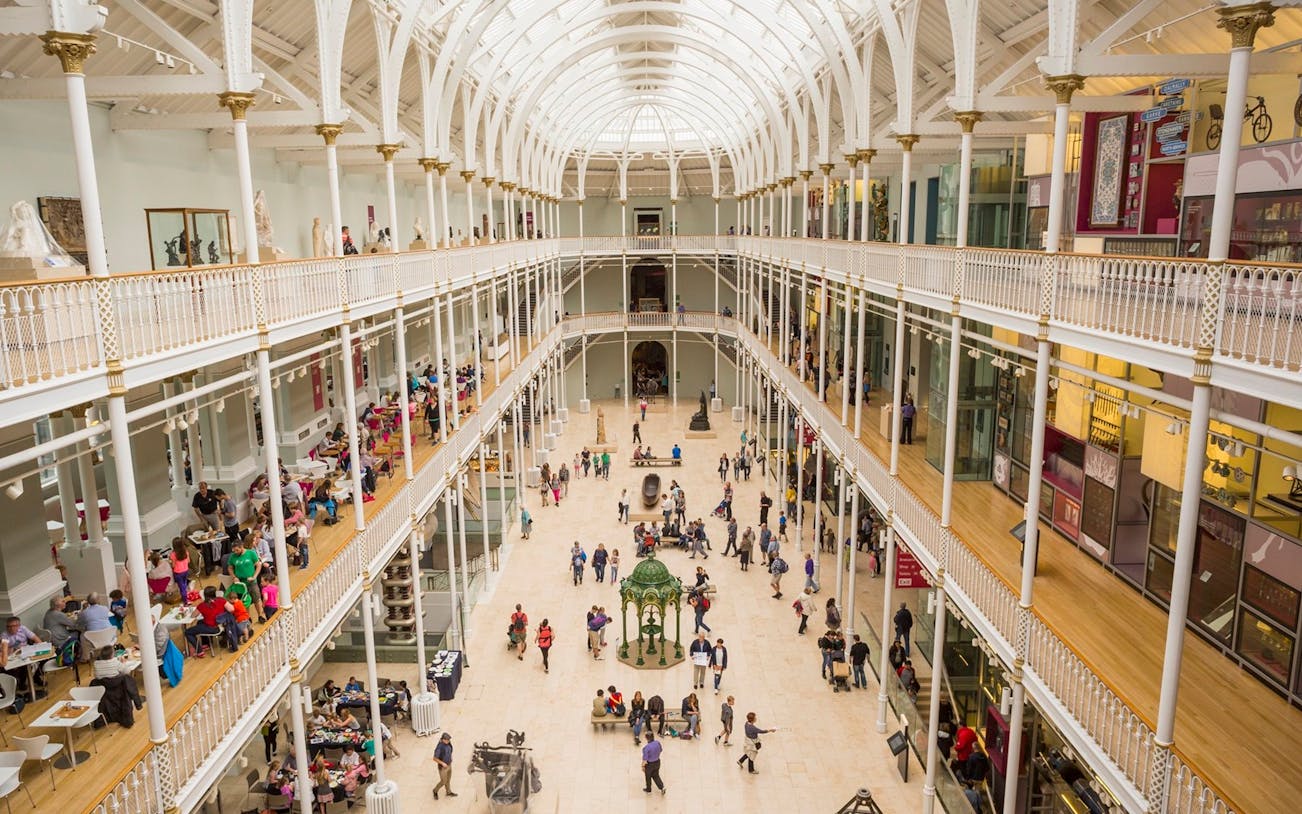 Visitors exploring the grand atrium of the National Museum of Scotland in Edinburgh.