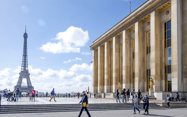 Eiffel Tower view from National Marine Museum, Paris, with people walking.