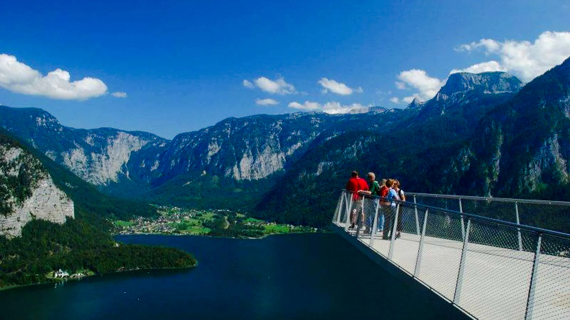 Visitors on Hallstatt Skywalk overlooking mountains and lake, part of Salzburg private tour.
