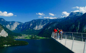 Visitors on Hallstatt Skywalk overlooking mountains and lake, part of Salzburg private tour.