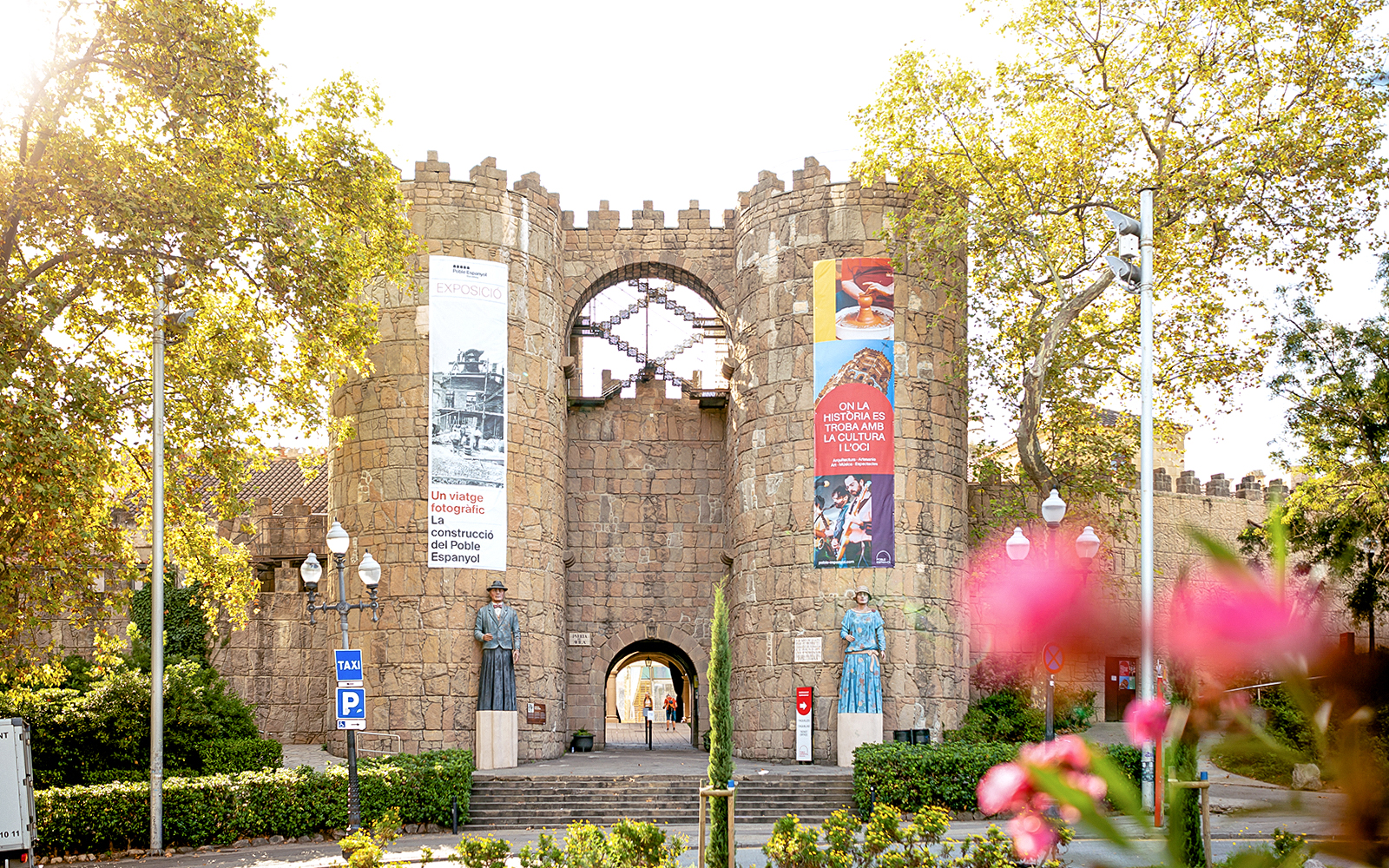 Tourists exploring Poble Espanyol in Barcelona with Skip-the-Line Tickets, admiring the unique architecture and vibrant streets