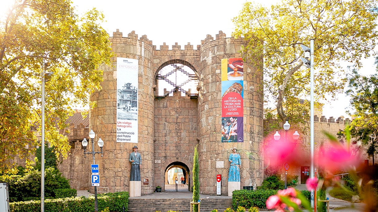 Tourists exploring Poble Espanyol in Barcelona with Skip-the-Line Tickets, admiring the unique architecture and vibrant streets