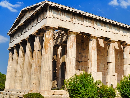 Temple of Hephaestus with Doric columns in Athens, Greece, under a clear blue sky.