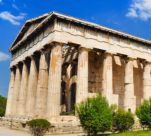Temple of Hephaestus with Doric columns in Athens, Greece, under a clear blue sky.