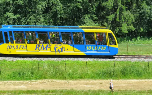 Train traveling through lush greenery on the Zakopane & Chochołów Thermal Baths Day Trip from Kraków.