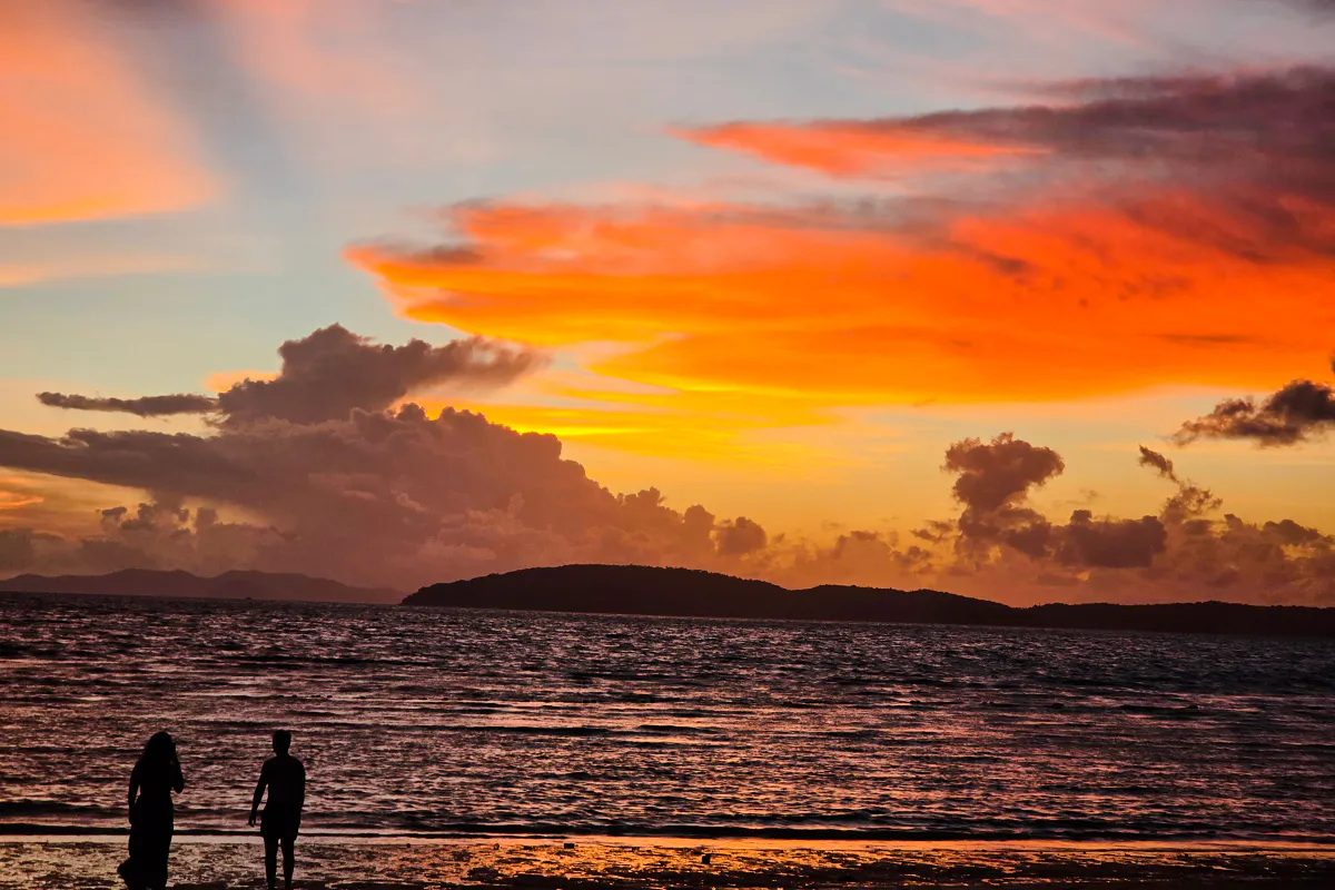 Sunset over Railay Beach with silhouettes of people, Krabi, Thailand.