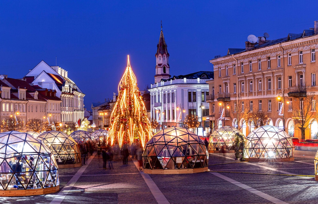 Christmas market stalls with festive lights in a European city.