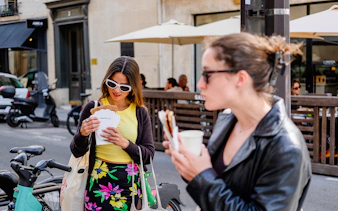 Person examining a polaroid while enjoying food on the Emily in Paris Food Tour.