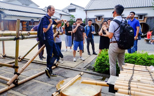 Tour group enjoying sake tasting at a traditional brewery in Kyoto.
