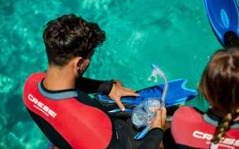 Snorkelers preparing gear on a boat near Rottnest Island's clear waters.
