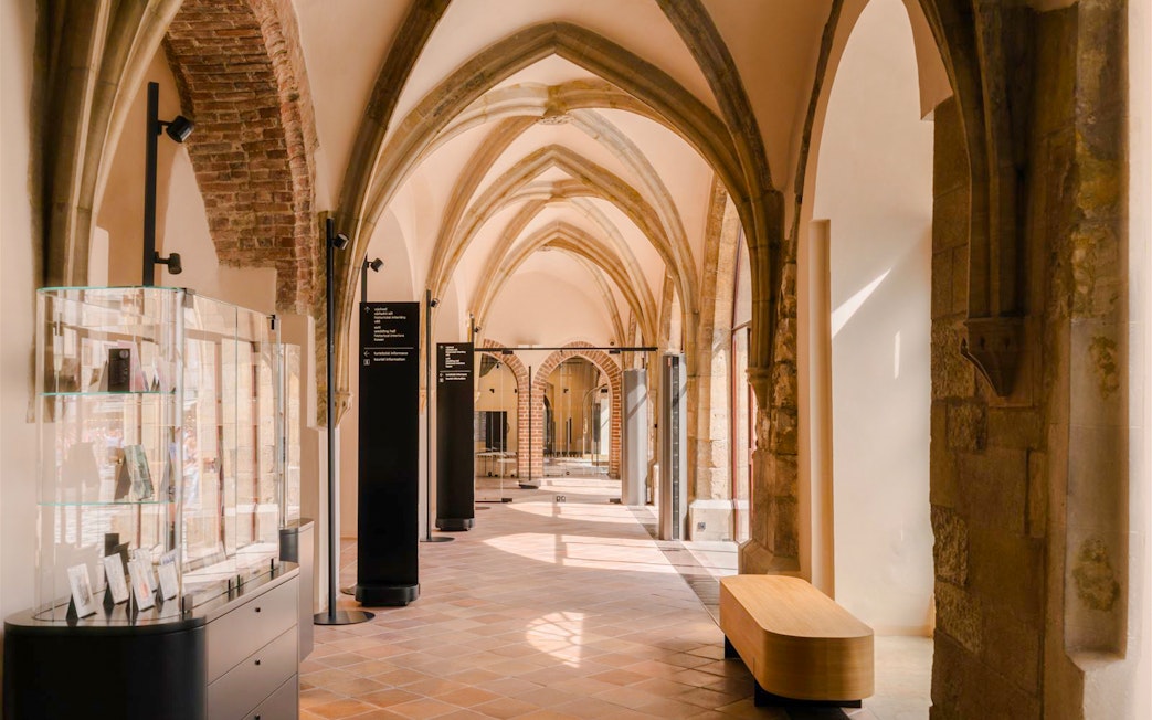 Gothic arches and display cases inside Old Town Hall, Prague.