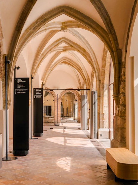 Gothic arches and display cases inside Old Town Hall, Prague.