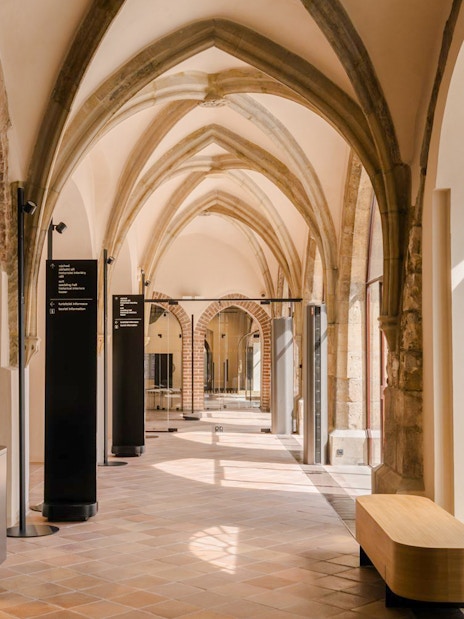 Gothic arches and display cases inside Old Town Hall, Prague.