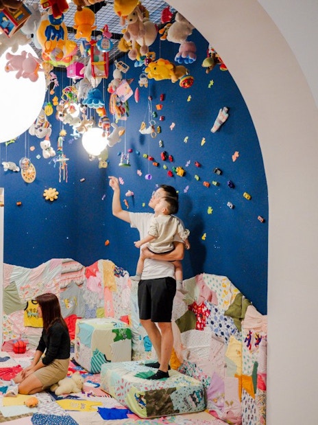 Family exploring interactive art installation at Children's Biennale, National Gallery Singapore.