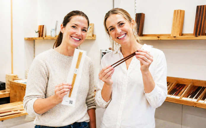 Participants displaying handmade chopsticks at a workshop in Ginza.