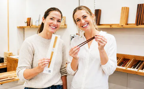 Participants displaying handmade chopsticks at a workshop in Ginza.