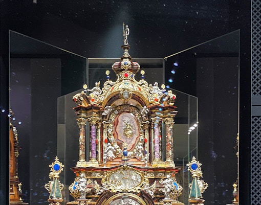 Ornate metalwork display at Wawel Castle, featuring intricate designs and colorful embellishments.