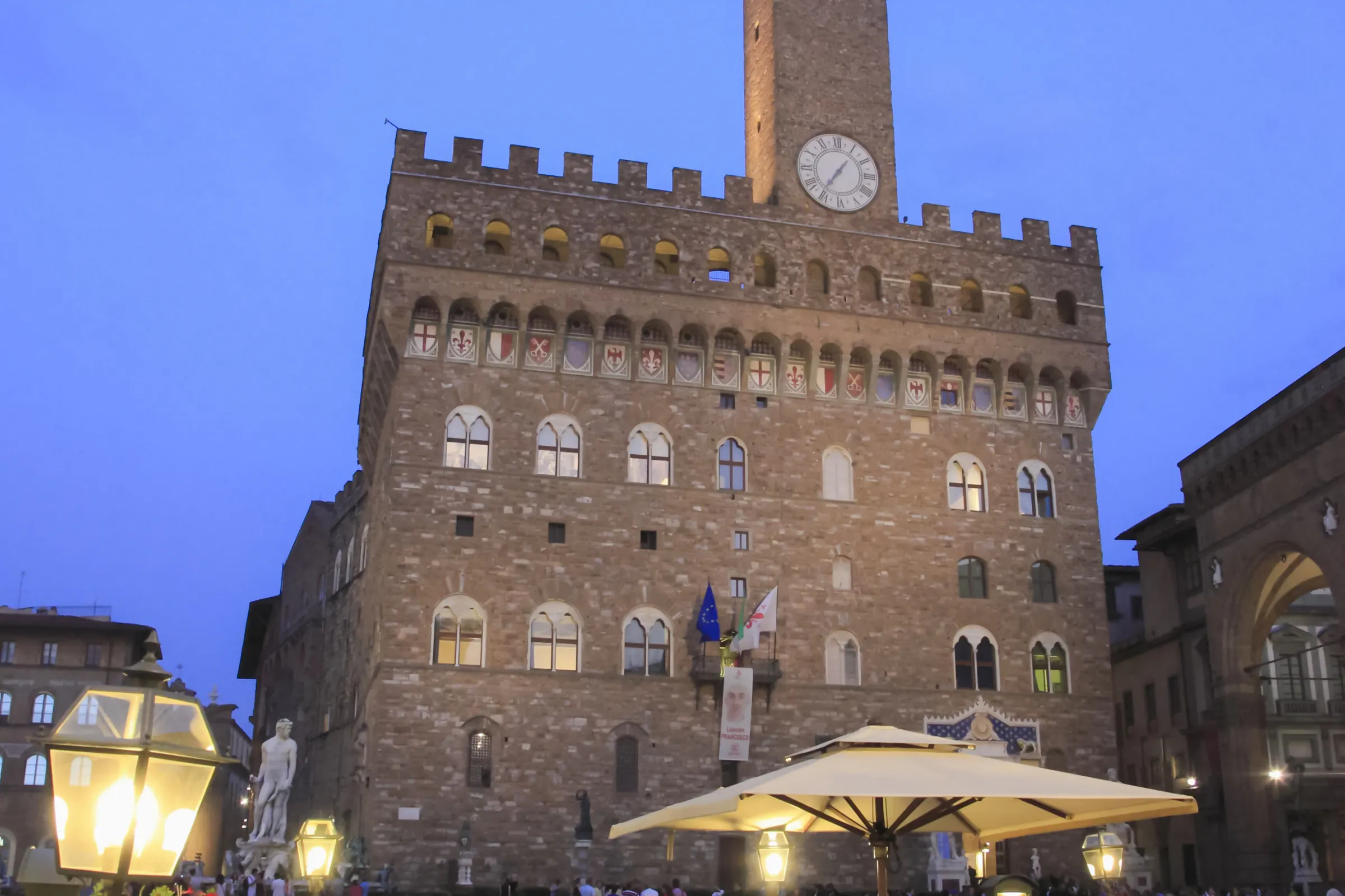Palazzo Vecchio at dusk in Florence, Italy, near a Tuscan dinner setting.