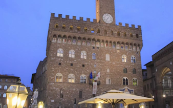 Palazzo Vecchio at dusk in Florence, Italy, near a Tuscan dinner setting.