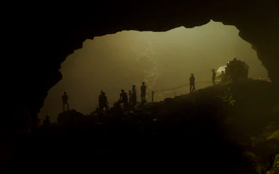 Tourists exploring Jomblang Cave in Yogyakarta during guided adventure tour.