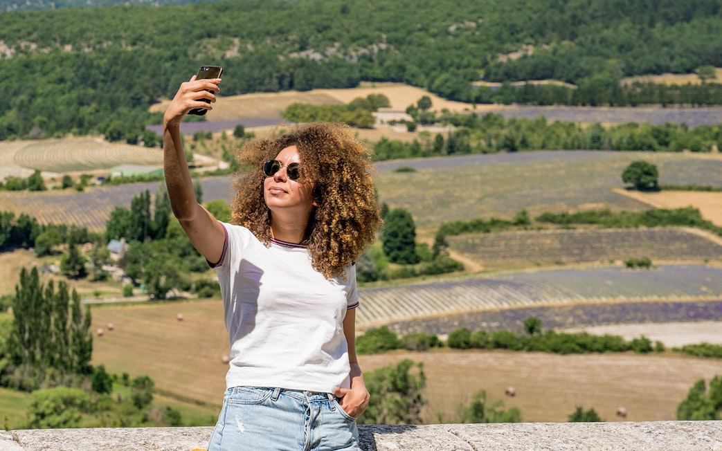 Person taking a selfie with Sault lavender fields in the background during a morning tour.