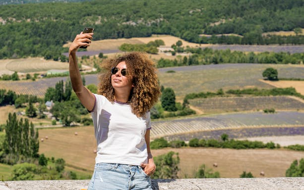 Person taking a selfie with Sault lavender fields in the background during a morning tour.