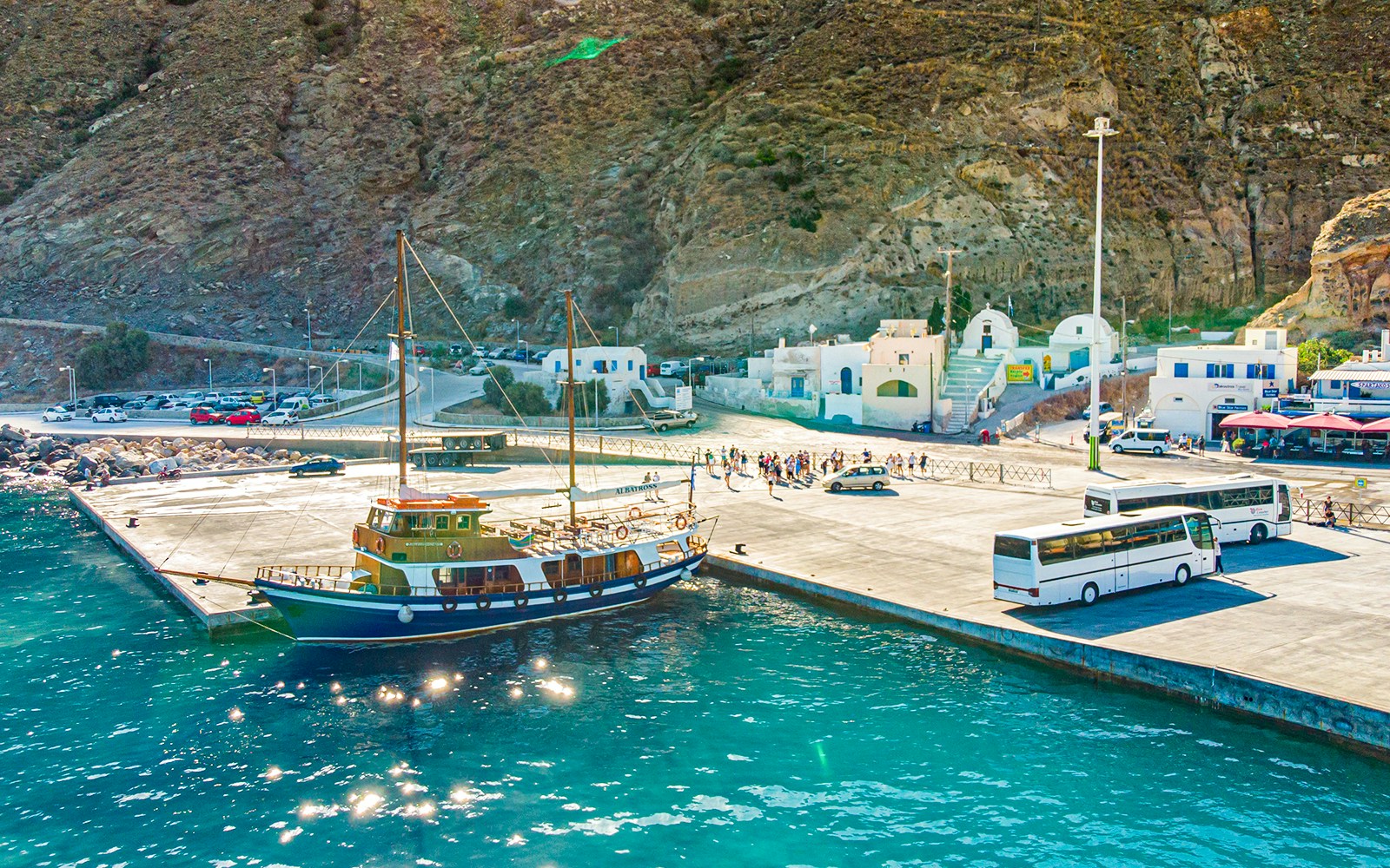 Santorini volcanic islands boat tour with view of caldera, hot springs, and Thirassia in the background.