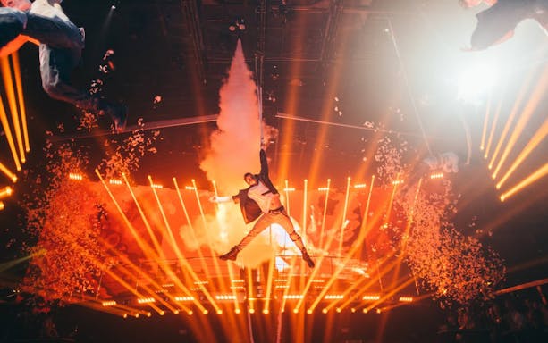 Performer suspended in air with dramatic lighting at Mad Max show, Coco Bongo.