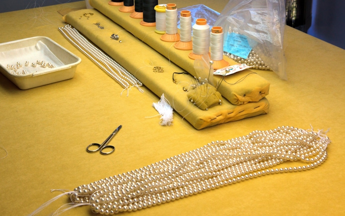 Pearl stringing station at a Mallorca factory with tools and materials.