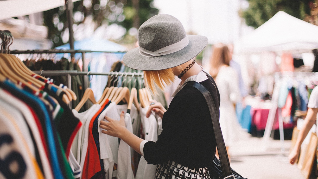 Shopper browsing clothes on a vibrant street market.