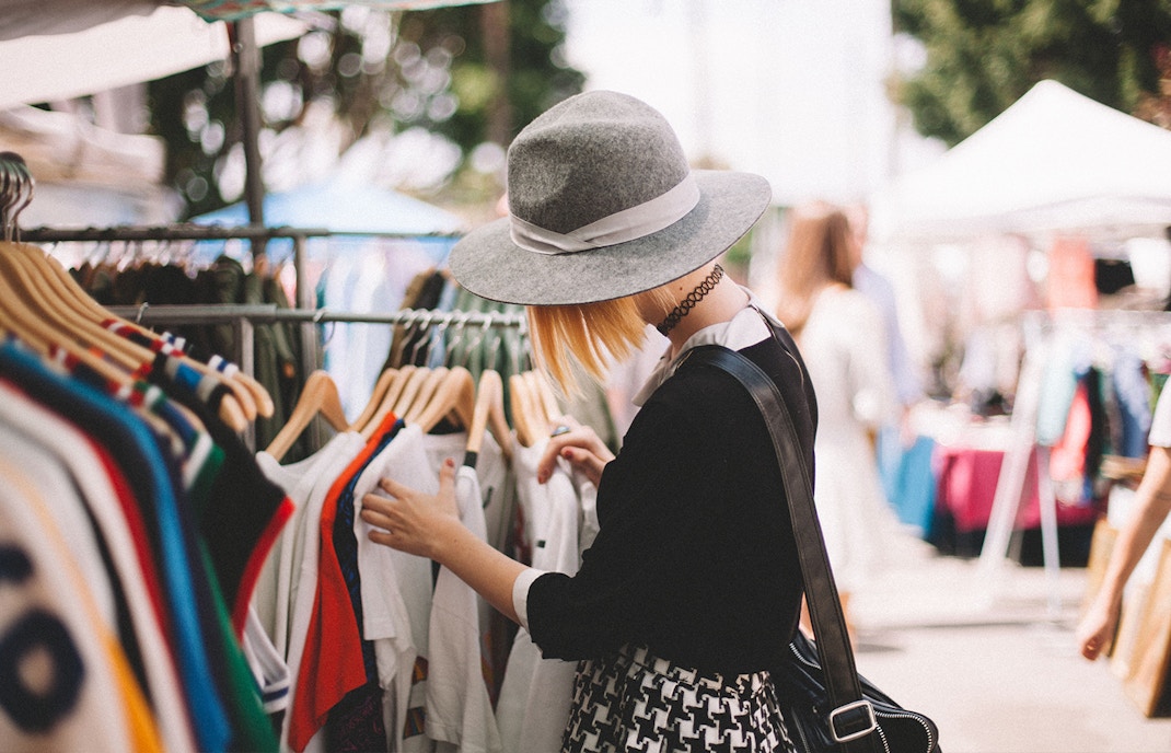 Shopper browsing clothes on a vibrant street market.