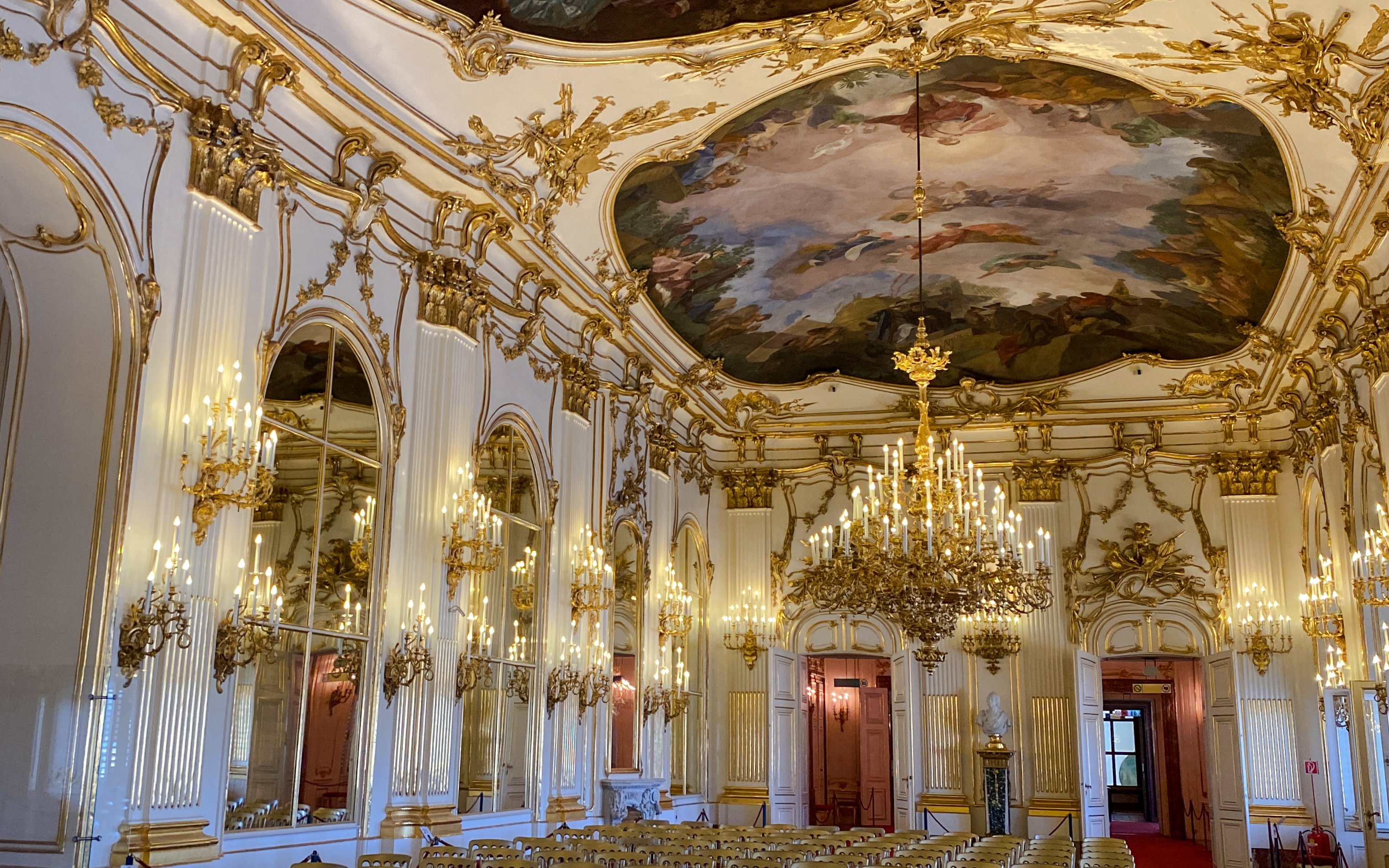 Schonbrunn Palace interior with ornate chandeliers and frescoed ceiling, Vienna.