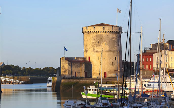 Towers of La Rochelle with boats in the harbor, France.