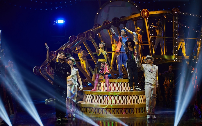 Performers on stage during Michael Jackson ONE show in Las Vegas, featuring vibrant costumes and dynamic poses.