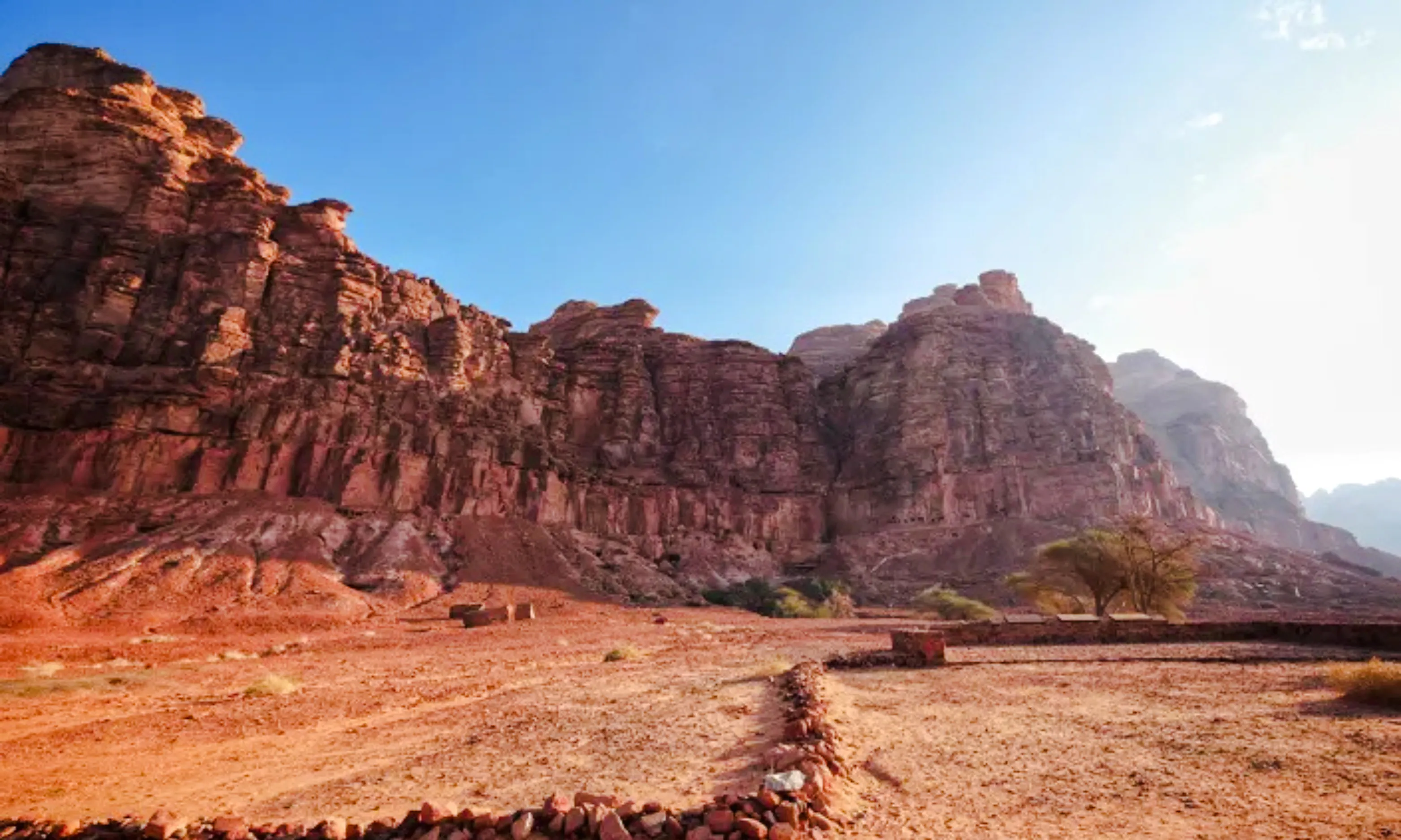 Rocky landscape of Hegra in AlUla, Saudi Arabia, with ancient stone formations and desert terrain.