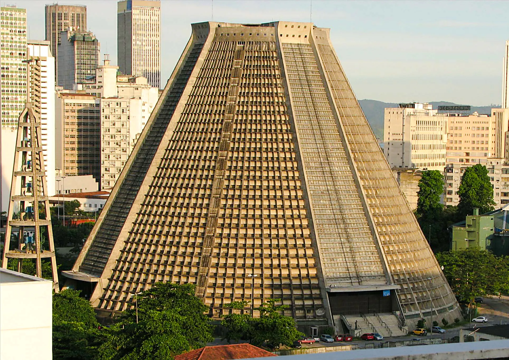 Cone-shaped cathedral in Rio de Janeiro cityscape, part of modern architecture tour.