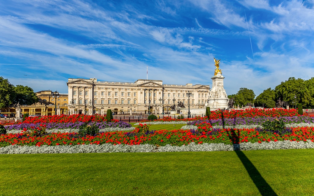 Buckingham Palace exterior with colorful gardens and Victoria Memorial in London.