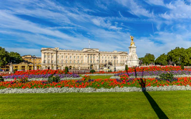 Buckingham Palace exterior with colorful gardens and Victoria Memorial in London.