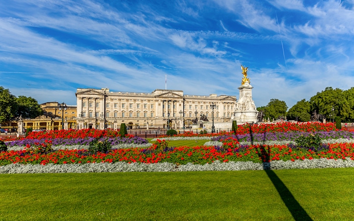 Buckingham Palace exterior with colorful gardens and Victoria Memorial in London.