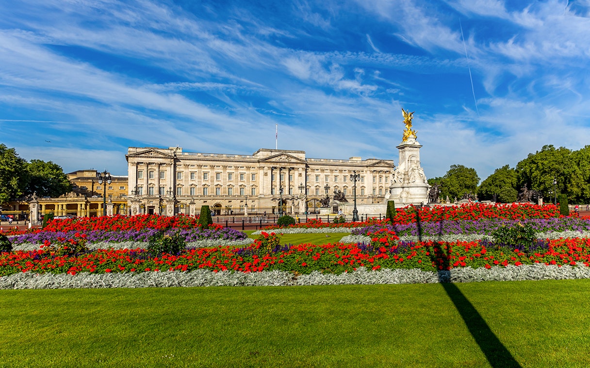 Buckingham Palace exterior with colorful gardens and Victoria Memorial in London.
