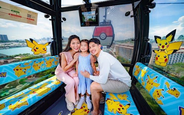 Family enjoying a ride in a Pokémon-themed Singapore Cable Car.