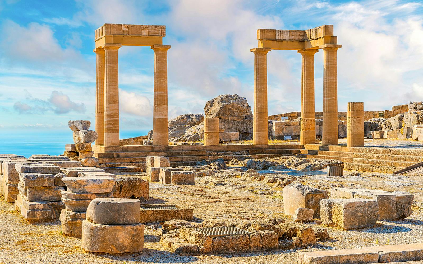 Ancient ruins of the Acropolis of Lindos with stone columns and scattered remnants.
