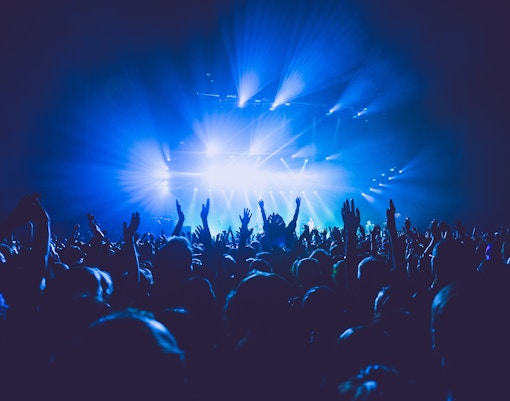 Dubai concert stage with vibrant lights and audience enjoying live music performance.