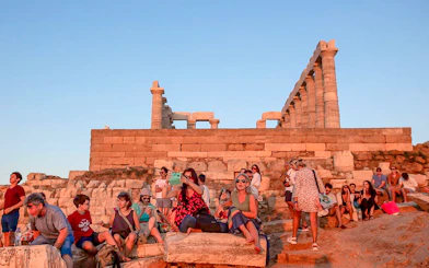 Visitors at Cape Sounion enjoying the sunset near the Temple of Poseidon.