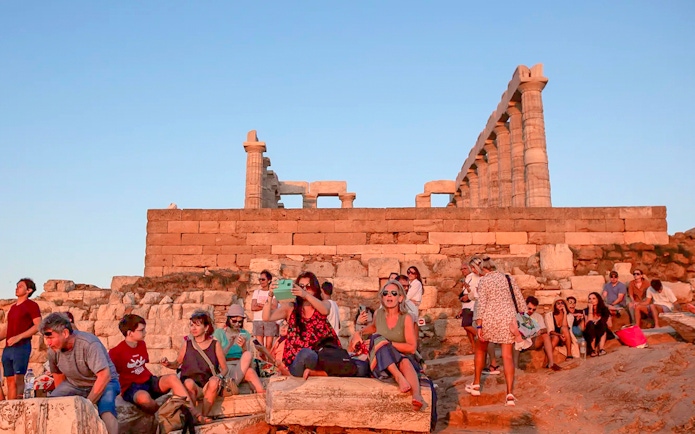 Visitors at Cape Sounion enjoying the sunset near the Temple of Poseidon.