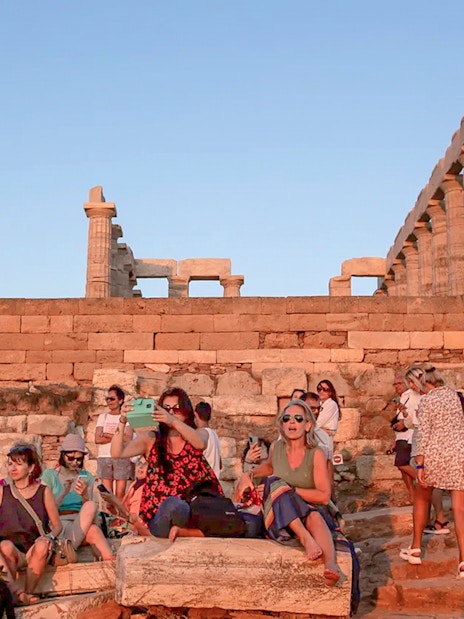 Visitors at Cape Sounion enjoying the sunset near the Temple of Poseidon.