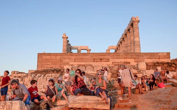 Visitors at Cape Sounion enjoying the sunset near the Temple of Poseidon.